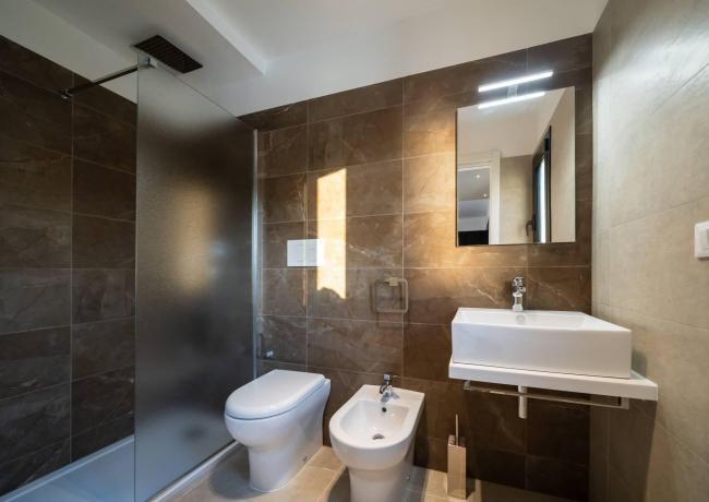 Bagno moderno con doccia, lavabo, WC e bidet.