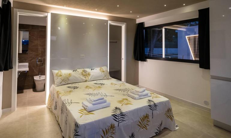 Camera moderna con letto matrimoniale e bagno privato.